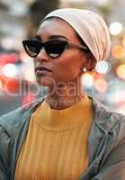 Looking for the next place to visit. an attractive young woman wearing a hijab and sunglasses while touring the city.