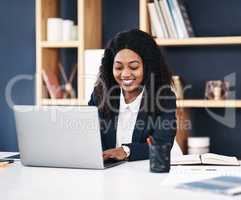 Know your worth and work hard to increase that. a young businesswoman using a laptop at her desk in a modern office.