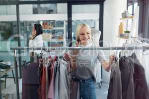 Shopper, customer and happy young woman out shopping and looking at and choosing clothing on a store railing. Trendy and confident female browsing through fashion collection in a retail shop