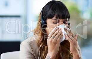 Will this cold just go away. an attractive young businesswoman suffering from a cold and blowing her nose while in her office.