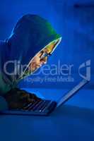 Your personal information is mine to use. a young male hacker using a laptop in the dark.