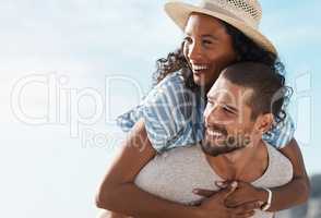 What a blissful day out together. a young man piggybacking his girlfriend at the beach.