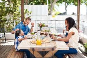 Our small little family is full of love and laughter. a beautiful young family enjoying themselves while having a meal together around a table outdoors.