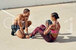 Lets work on those abs. a young woman working out with her personal trainer.