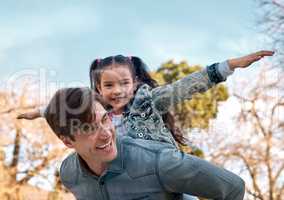 Are you ready for takeoff. an adorable little girl enjoying a piggyback ride with her father at the park.