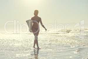 I believe I can fly just like every surfer does. a young woman out at the beach with her surfboard.