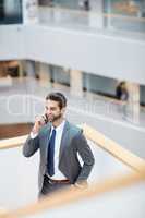 I hope youre calling with some good news. a young businessman talking on a cellphone in an office.