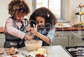 Trying moms flop proof recipe. a young boy and girl baking in the kitchen at home.