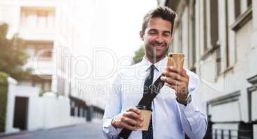 Looks like my inbox has a lot of images. a handsome young businessman texting on his cellphone while heading to work in the morning.