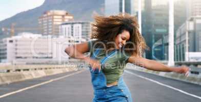 Dance more, stress less. an attractive young woman performing a street dance routine during the day while outdoors.