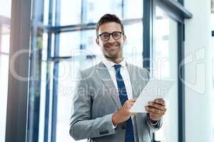 Use technology to improve your success. a professional businessman using a digital tablet in his office.