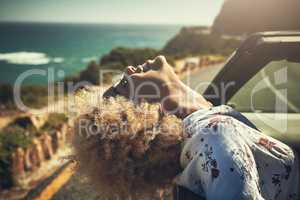 Let your mind go on a trip. Cropped hot of a young woman enjoying herself on a road trip.