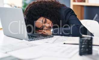 Its time to call it day. a young businesswoman sleeping at her desk in a modern office.