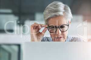 These figures arent adding up at all. an attractive mature businesswoman adjusting her glasses while working on a laptop in her office.