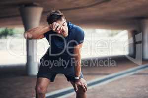 Sweat is proof of how powerful youre becoming. a sporty young man taking a break while exercising outdoors.