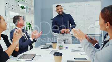 He deserves all the applause and accolades. a young businessman being given a round of applause during a boardroom meeting with colleagues at work.