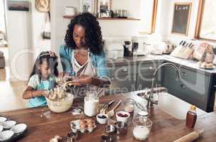 Our most basic instinct is not for survival but for family. a woman baking at home with her young daughter.