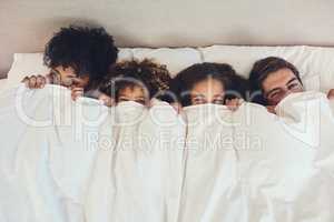 Theyre a family who share tons of fun together. Portrait of a family lying down in bed together at home.