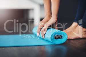 Shes well equipped for her session. an unrecognizable young woman rolling up her yoga mat in her bedroom.