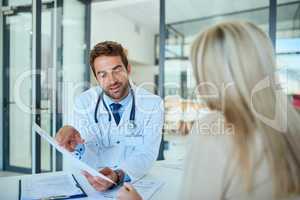 The tests show youre actually in great health. a handsome doctor going over some paperwork with a female patient in a clinic.