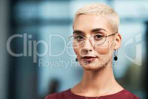 Focused and goal-driven. Cropped portrait of an attractive young businesswoman wearing spectacles and standing alone in her office.