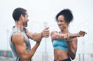 Motivating each other to be better. two sporty young people stretching while exercising outdoors.