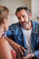 We dont really have much of an option. a mature man looking worried while having a discussion with his wife at home.