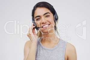 Helpful advice is just a call away. Studio portrait of an attractive young female customer service representative wearing a headset against a grey background.