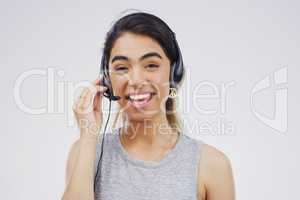 At the ready to handle any call. Studio portrait of an attractive young female customer service representative wearing a headset against a grey background.