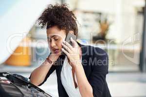 Car troubles will frustrate you in a minute. a frustrated young businesswoman calling roadside assistance after her car broke down.