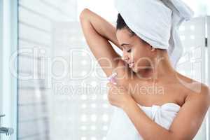 Lets talk about armpit care... an attractive young woman shaving her underarms with a razor in the bathroom.