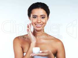 Apply the cream gently. Portrait of an attractive young woman posing while applying cream to her face against a white background.