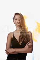 Youve gotta be confidence. Studio portrait of an attractive young woman standing with her arms folded against a brightly lit background.