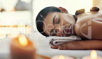 Rest now and just enjoy the experience. a young woman getting a hot stone massage at a spa.