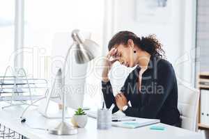 How many more challenges do I have to face today. a young businesswoman looking stressed out while working in an office.