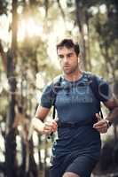 Full steam ahead on his hike. a handsome young man running during his hike in the mountains.