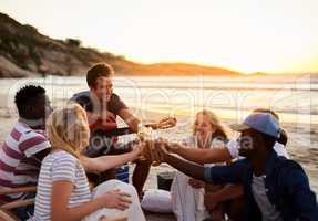 Celebrating the beauty of friendship. a group of friends enjoying drinks on the beach.