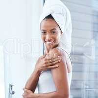 lock in all that moisture. a young woman applying moisturizer to her body.