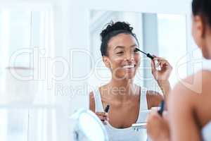 Starting my day with some drama. a beautiful young woman applying mascara in her bathroom mirror.