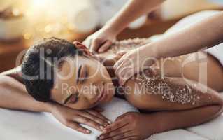 The ideal treatment for skin detoxification. a young woman getting an exfoliating massage at a spa.