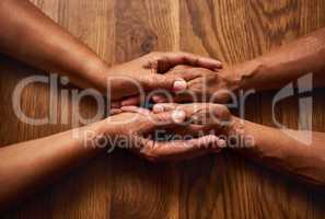 The bond we share can never be broken. High angle shot of an unrecognizable senior couple holding hands together over a wooden table at home.