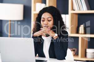 Waiting on that important email of confirmation. a young businesswoman using a laptop at her desk in a modern office.