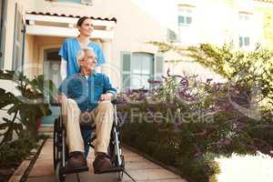 Fresh air is good for your health. a young female nurse outside with a senior patient in a wheelchair.