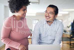 Awesome ideas from awesome teammates. a young businessman and businesswoman using a laptop in a modern office.