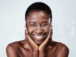Its my time to shine. Studio portrait of a beautiful young woman feeling her skin against a grey background.