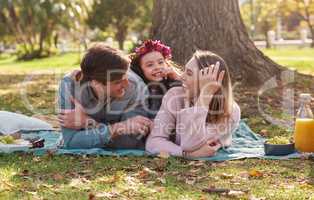 Nothing says family time like a picnic in the park. a happy young family enjoying a picnic in the park.