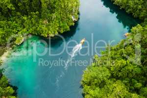 Set sail and discover new worlds of adventure. High angle shot of a boat sailing through a canal running along the Raja Ampat Islands in Indonesia.