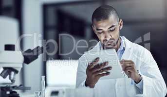 Healthcare science professional with tablet searching, browsing and reading test result for marburg virus, ebola or monkeypox cure. Serious biologist, scientist or pathologist in lab medical research