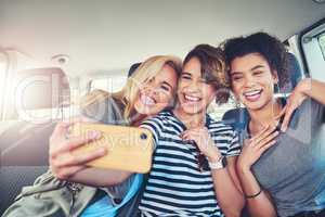 These are the moments we cherish the most. young women taking a selfie while out on a road trip together.