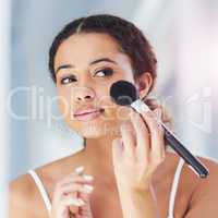 Add a dash of glitter to every day. a young woman applying makeup to her cheeks in the bathroom at home.